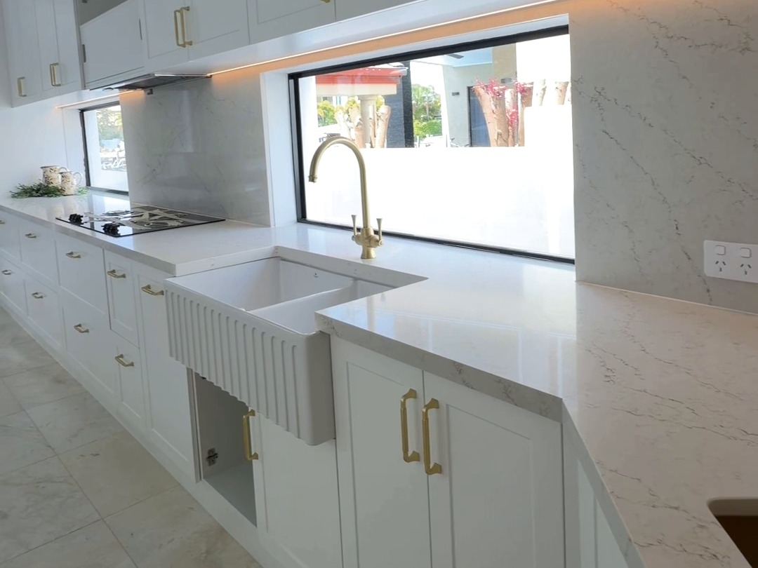Bright kitchen with fluted sink, brass tap and under-cabinet LED lighting